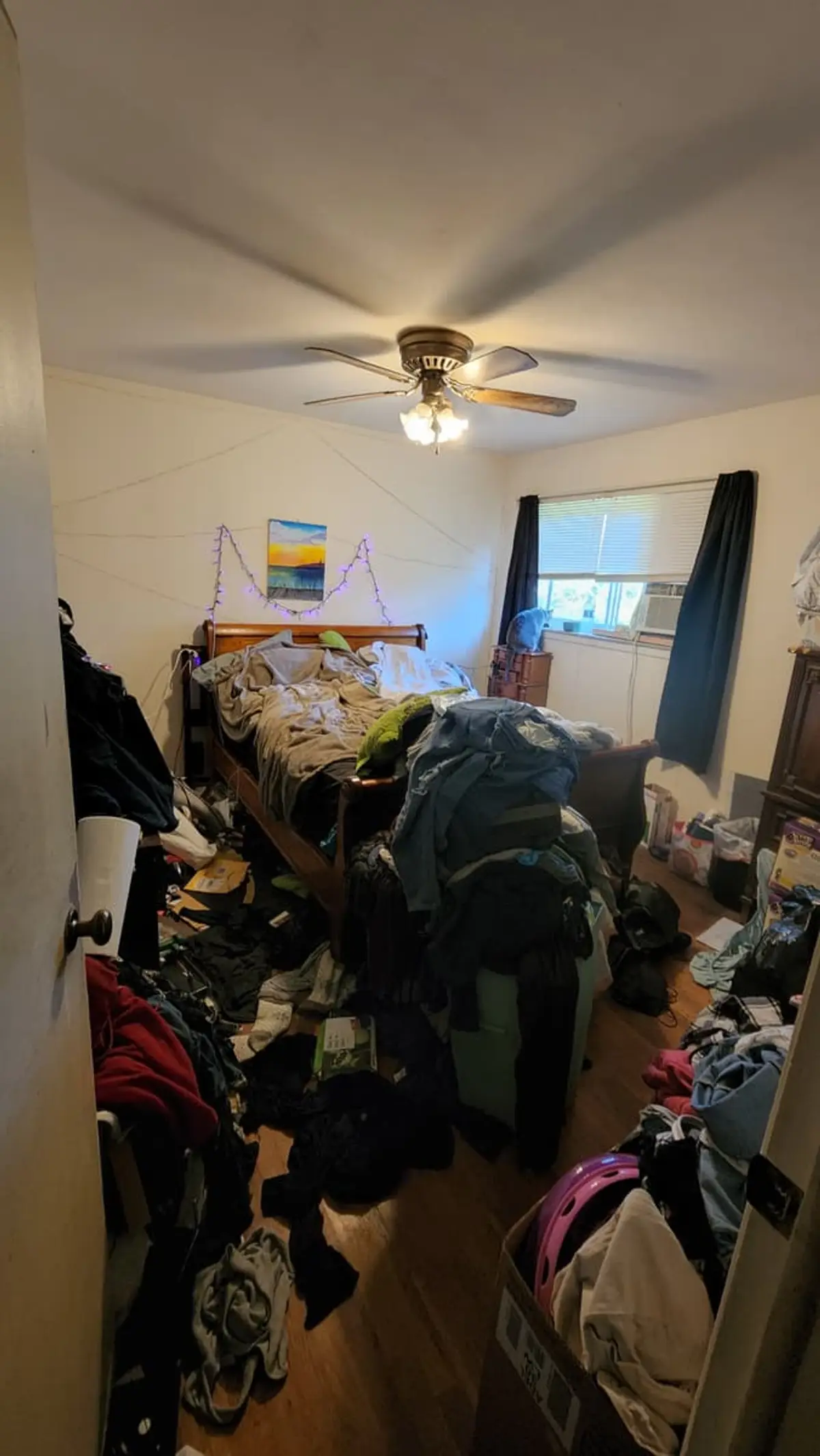 Selling a hoarder house in Brentwood: bedroom piled high with clothes and bags