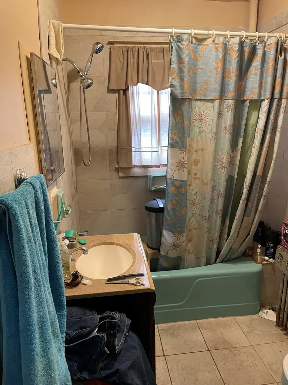 Downsizing or retiring in Brentwood: dated bathroom with a mint-green tub and patterned curtains
