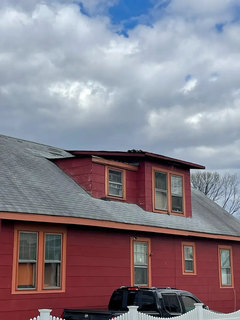 Red two-story house with a gabled dormer, Brentwood, NY