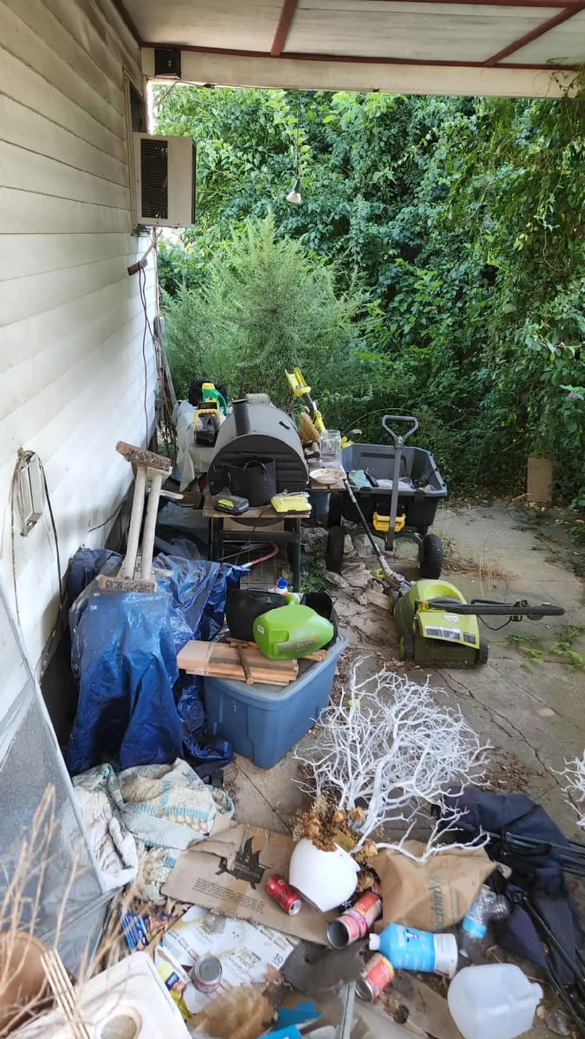 Dealing with squatters or holdover tenants in Brentwood: side porch packed with bins, bags and yard debris