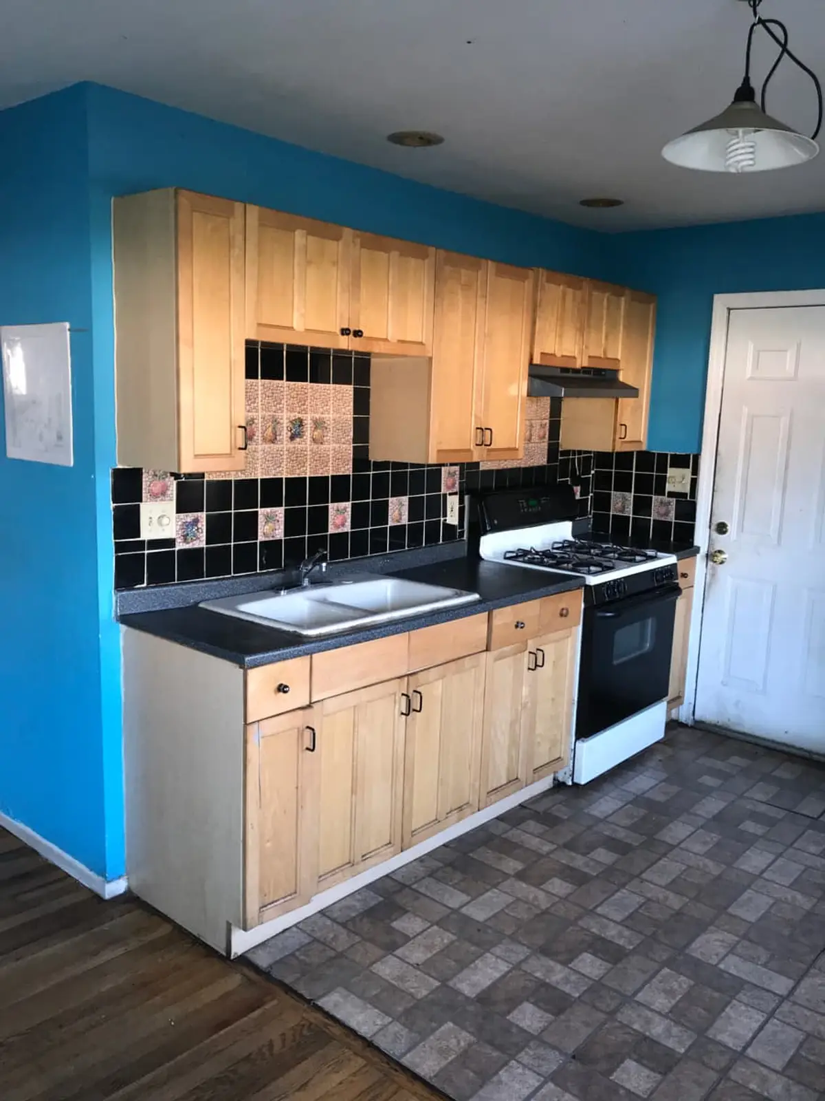 Selling a house for a job relocation in Brentwood: vacant kitchen with blue walls and light wood cabinets